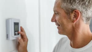 Man changing thermostat settings