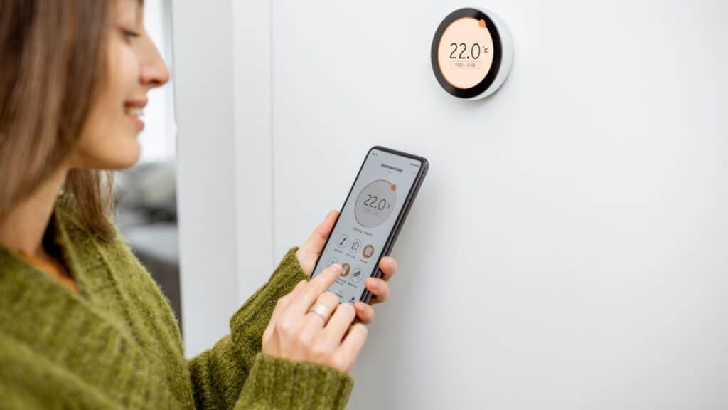 Woman adjusting smart thermostat